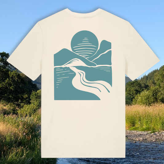 An off-white short-sleeve t-shirt with a teal and white minimalist landscape graphic on the front, set against a scenic outdoor background of a river, grass, and trees under a blue sky.