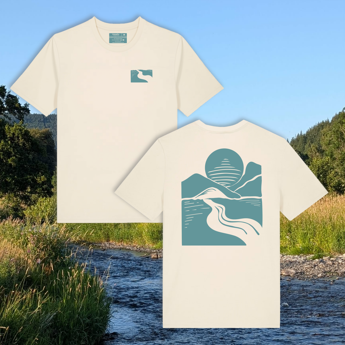 Two cream-colored short-sleeve t-shirts shown against a scenic outdoor background of a river and forest. The front shirt features a small teal river banks logo on the left chest, and the back shirt features a large teal and white landscape graphic with a sun, mountains, and river.